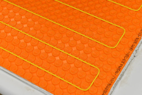 Floor heating with ThermoTile cable on Schluter membrane installation step 4 – Position heating cable between the studs on the membrane. Step 4 of installation of floor heating with ThermoTile cable on Schluter membrane is to position heating cable between the studs on the membrane.
