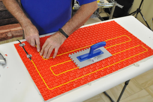 Floor heating with ThermoTile cable on PROVA membrane installation step 4 - Position heating cable between the studs on the membrane. Step 4 of installation of floor heating with ThermoTile cable on PROVA membrane is to position heating cable between the studs on the membrane.